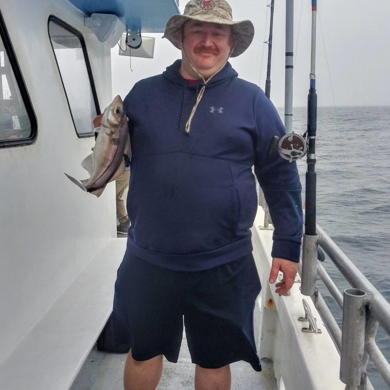 a woman holding a fish on a boat
