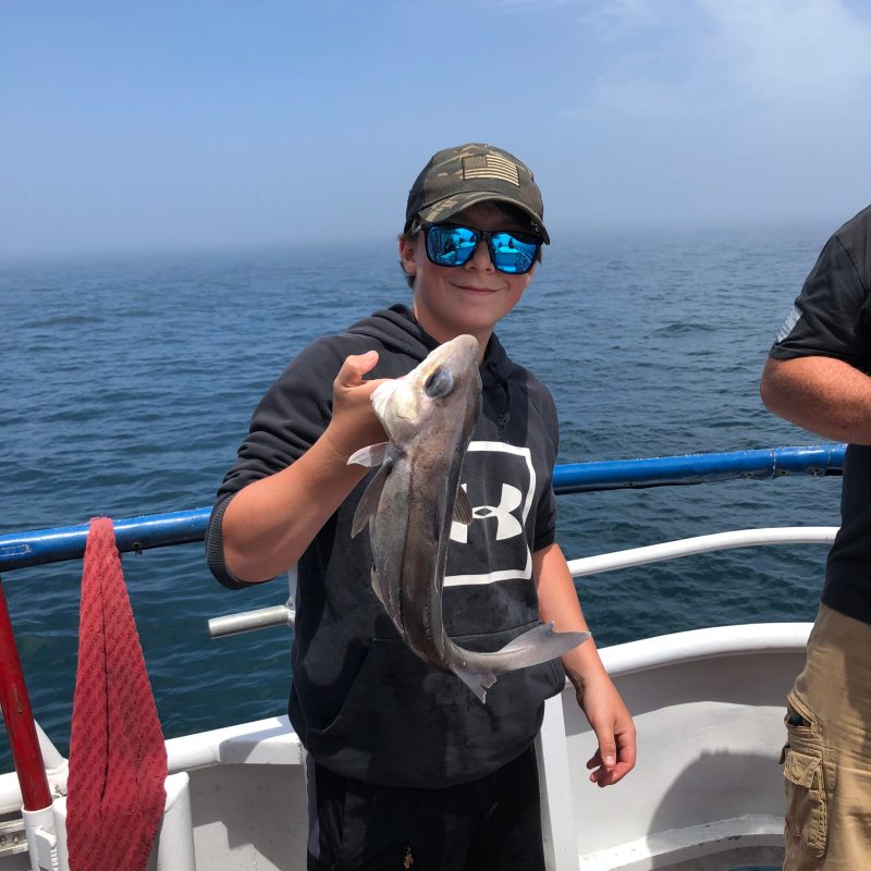 a man standing next to a body of water