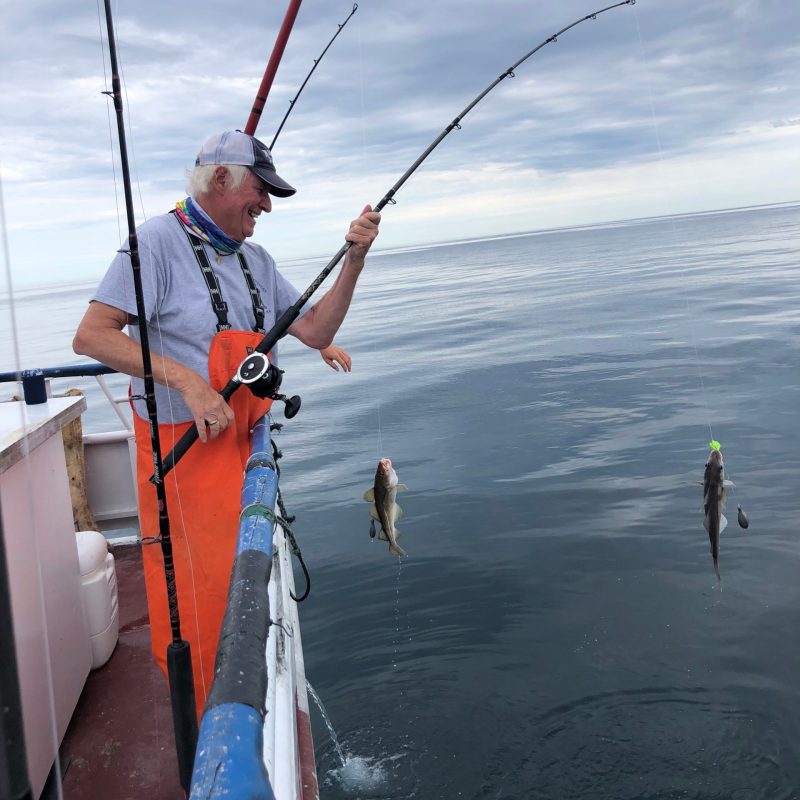 a man standing next to a body of water