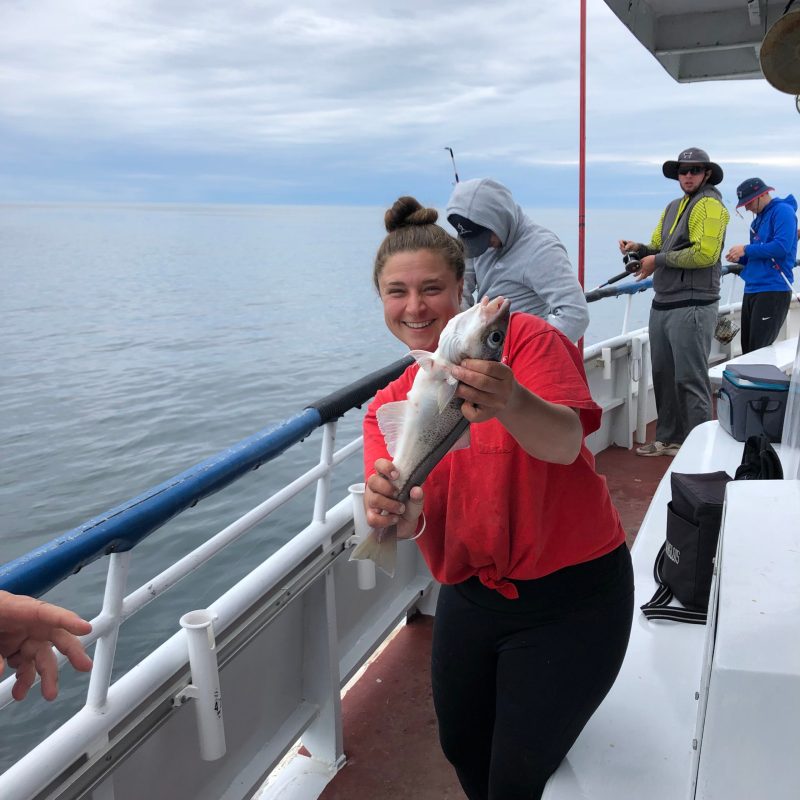 a man and a woman standing next to a body of water