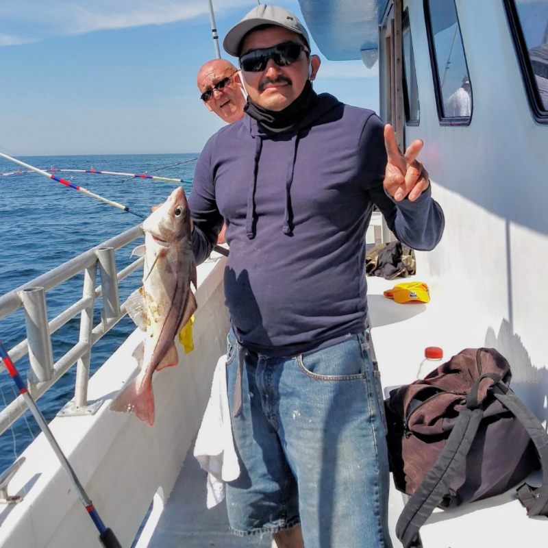 a person holding a fish on a boat