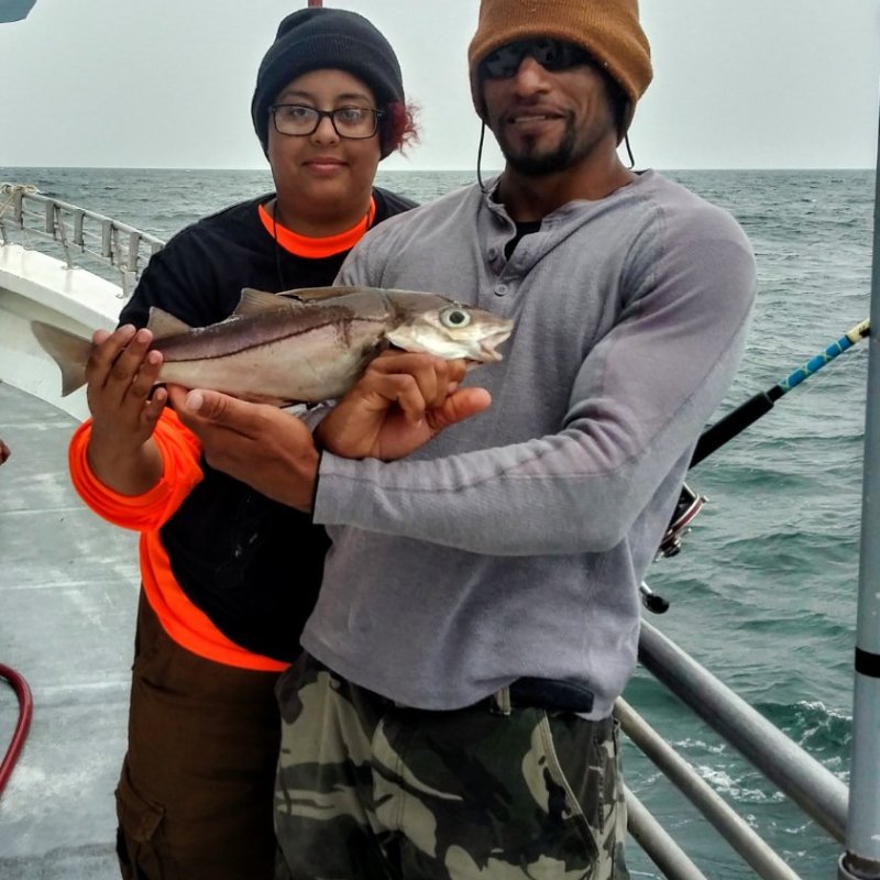 a man and a woman standing in front of water