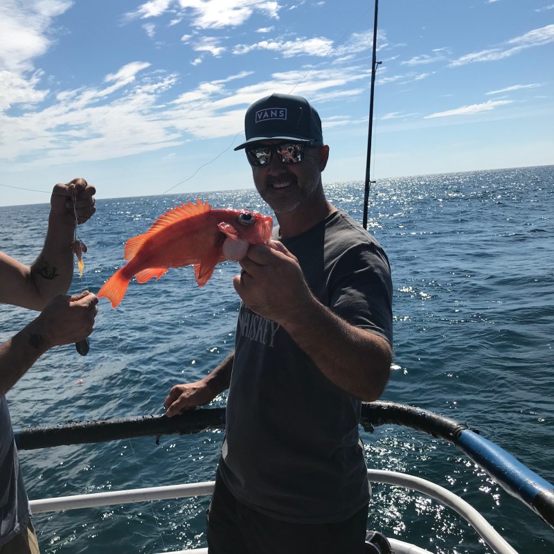 a man standing next to a body of water