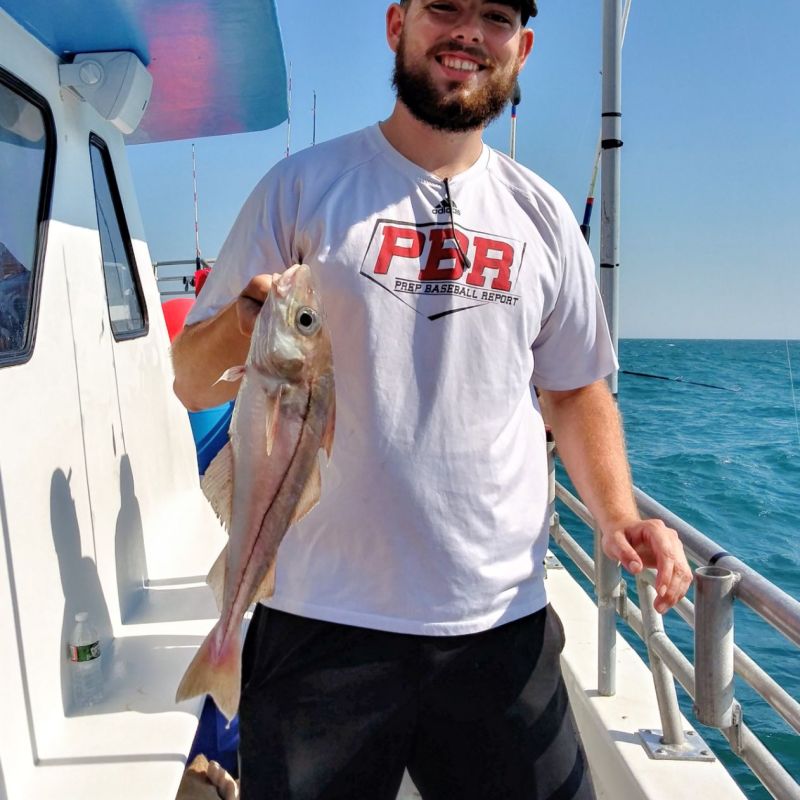 a man holding a fish on a boat