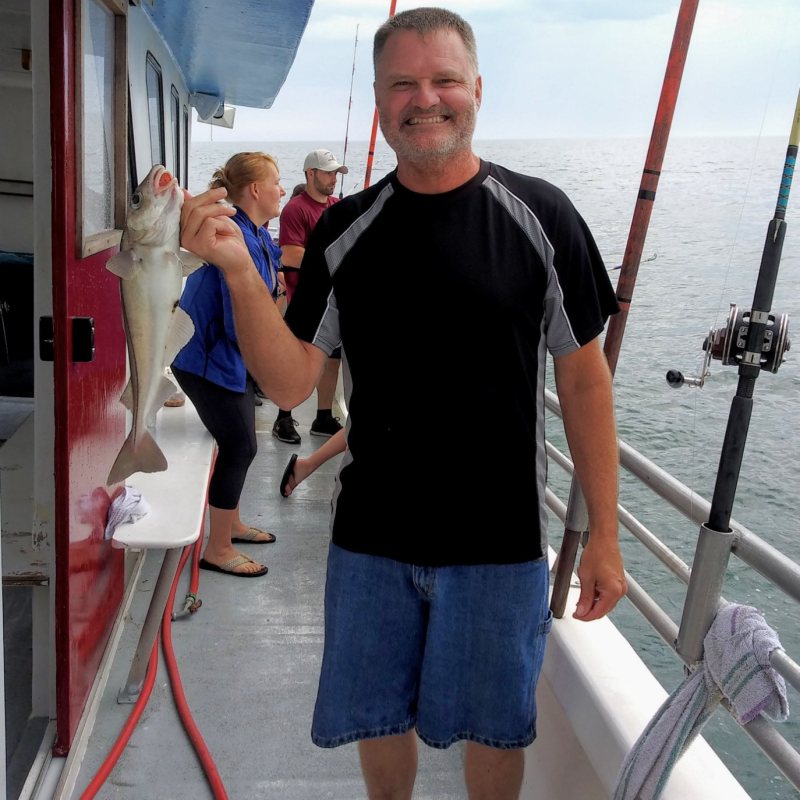 a man and a woman standing next to a boat