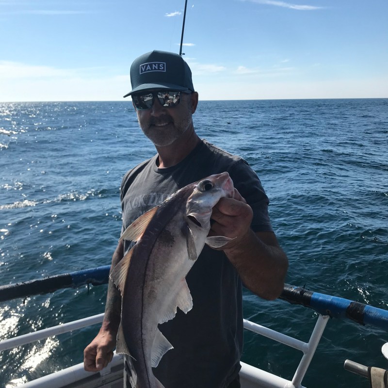 a man holding a fish in the water