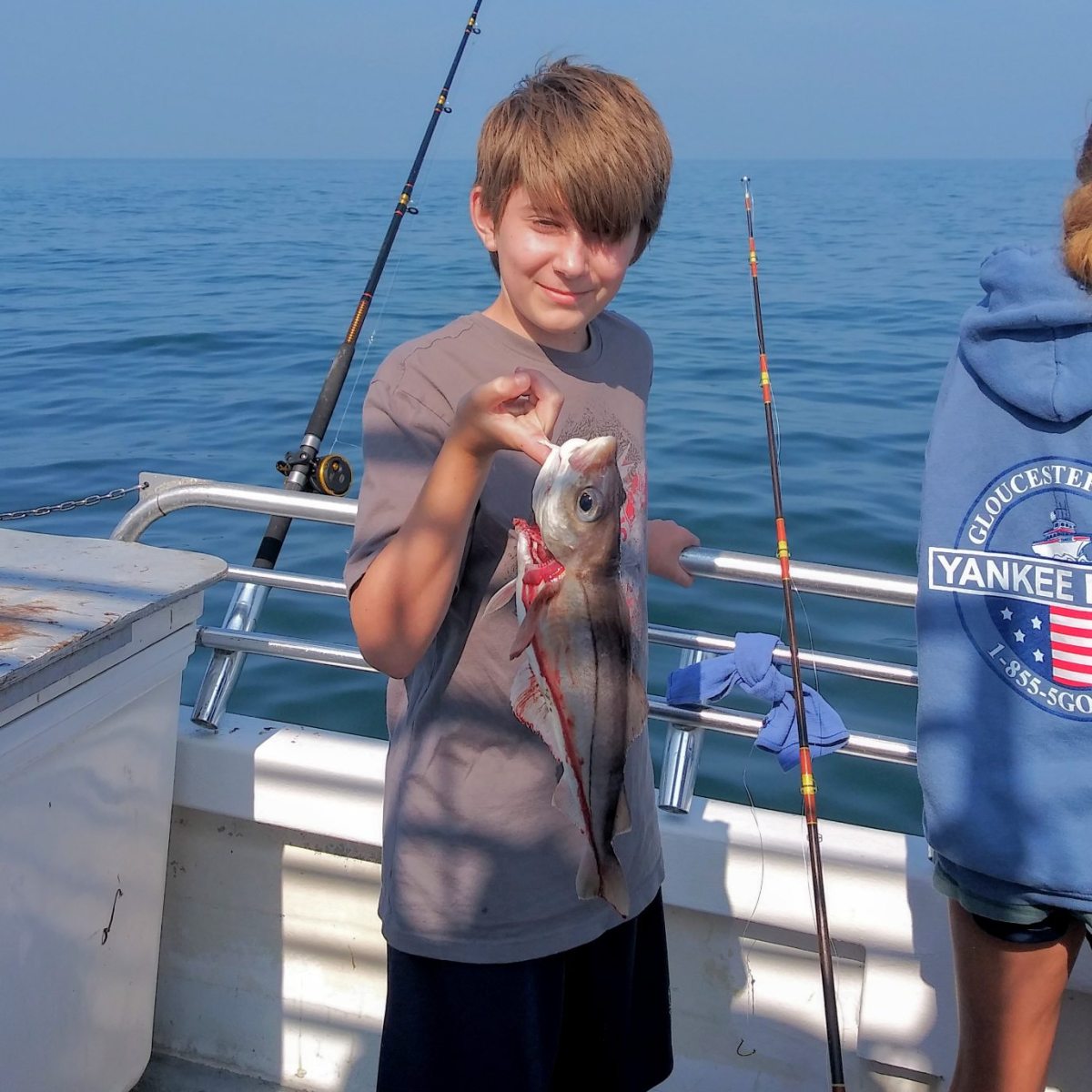 a person holding a fish on a boat in the water