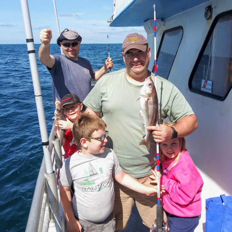 a person holding a fish on a boat