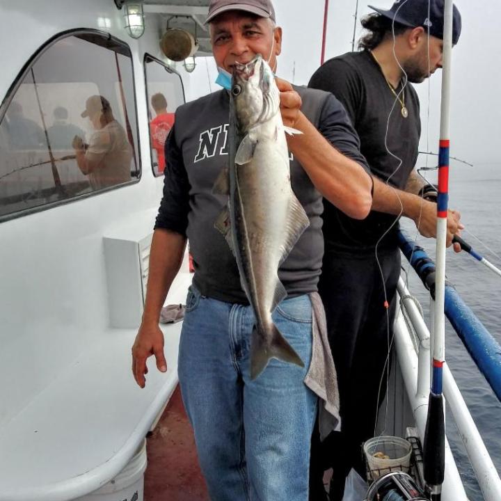 a man holding a fish on a boat