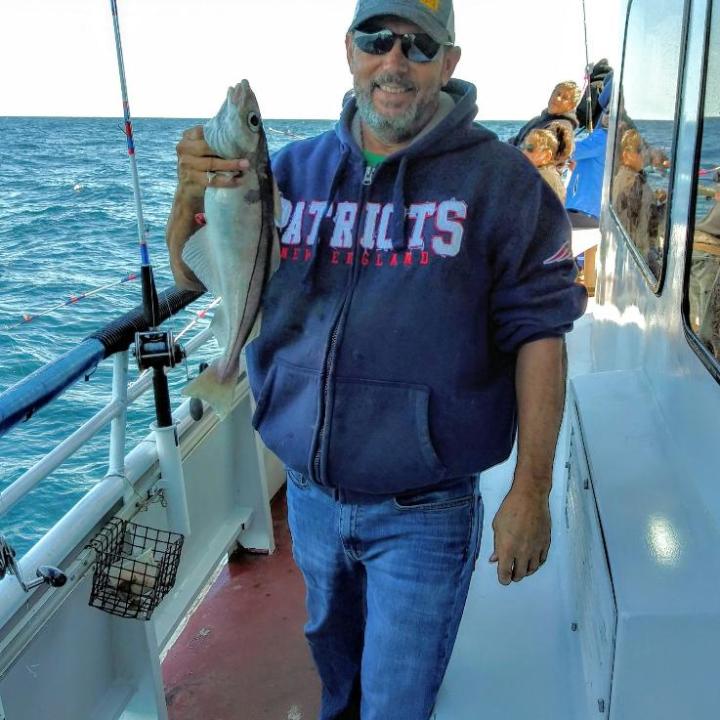 a person holding a fish on a boat