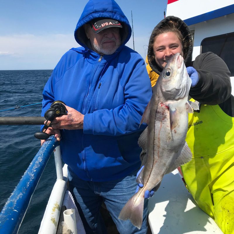 a person holding a fish on a boat