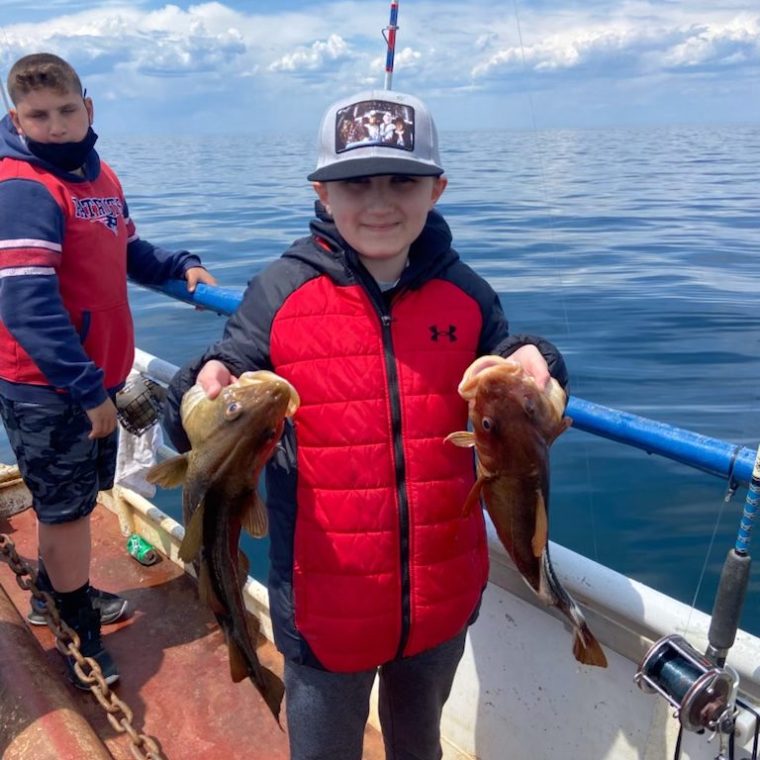 a group of people standing next to a body of water