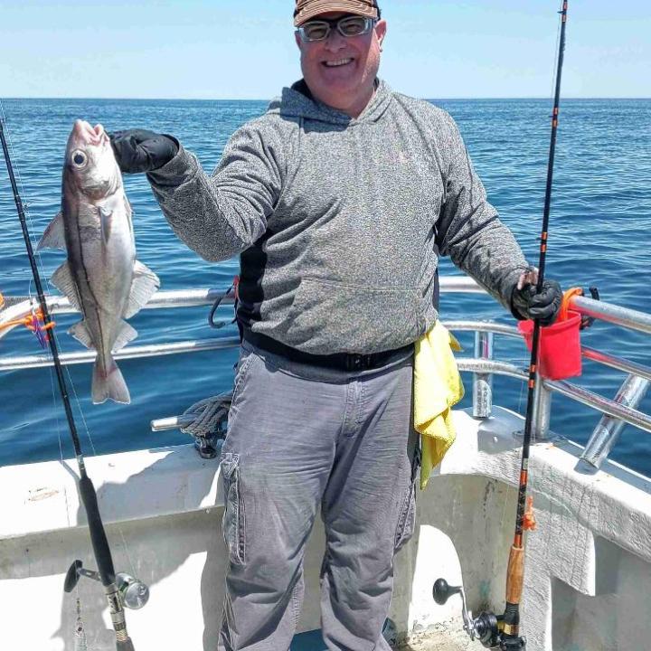 a person holding a fish on a boat in the water