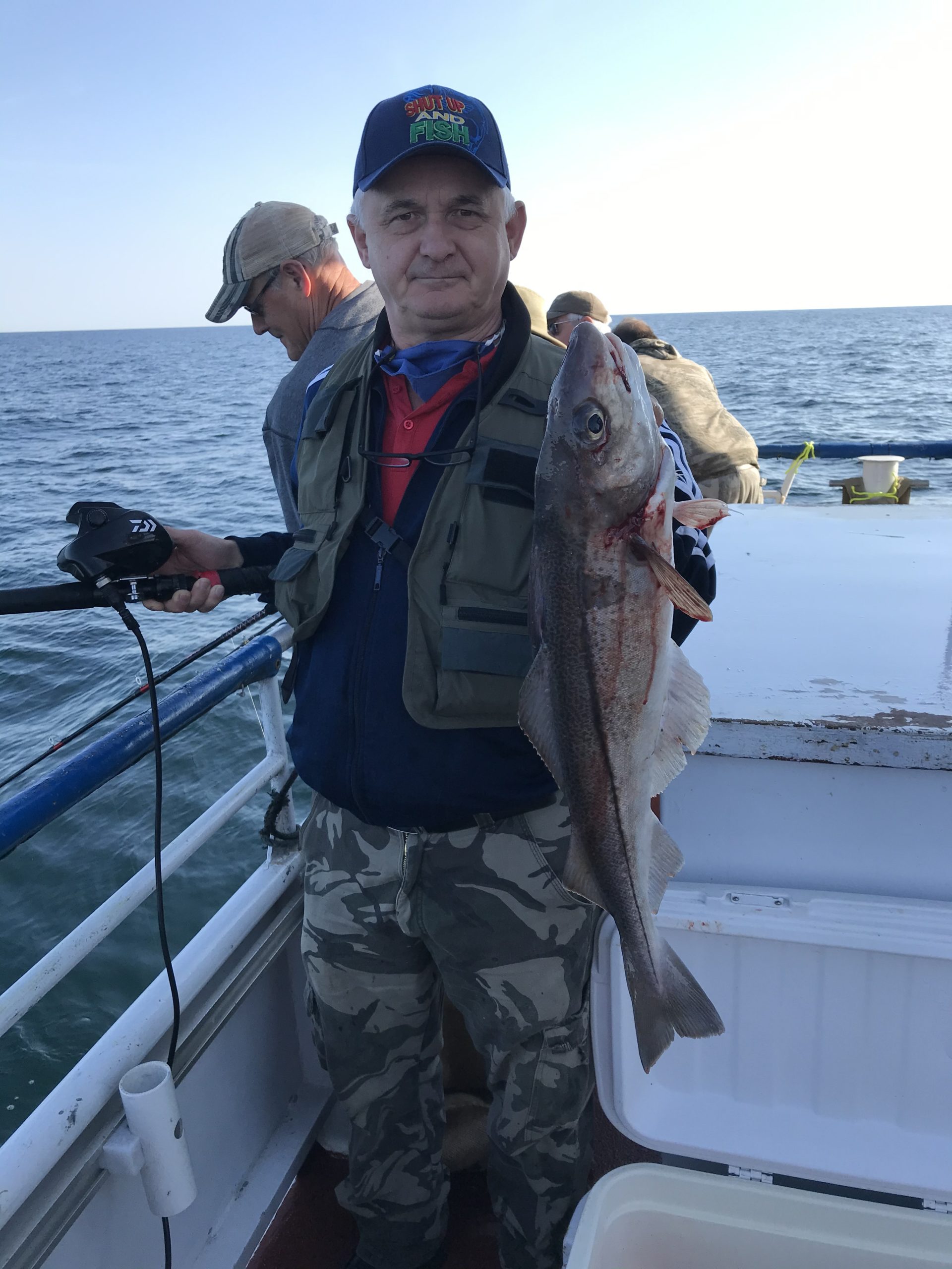 a person holding a fish on a boat in the water