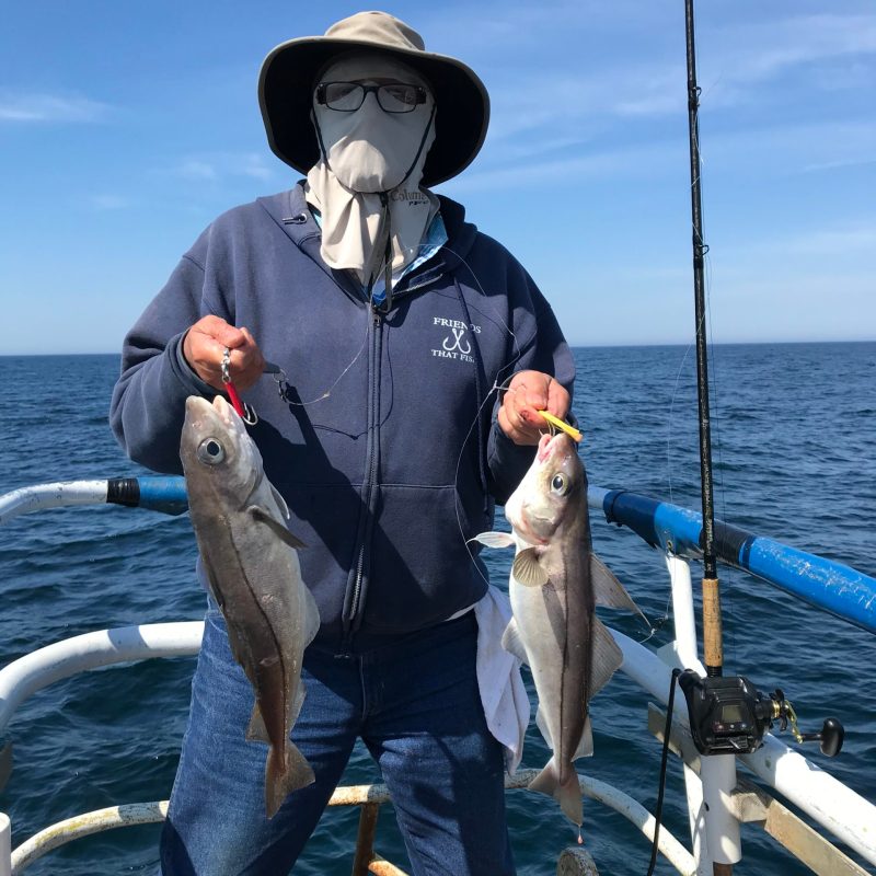 a person holding a fish on a boat