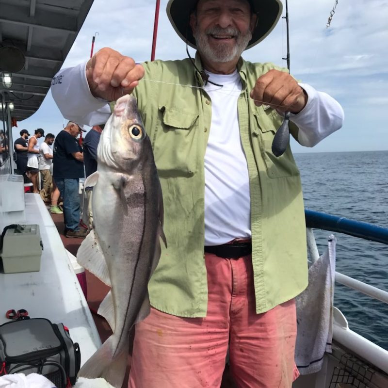 a man holding a fish on a boat