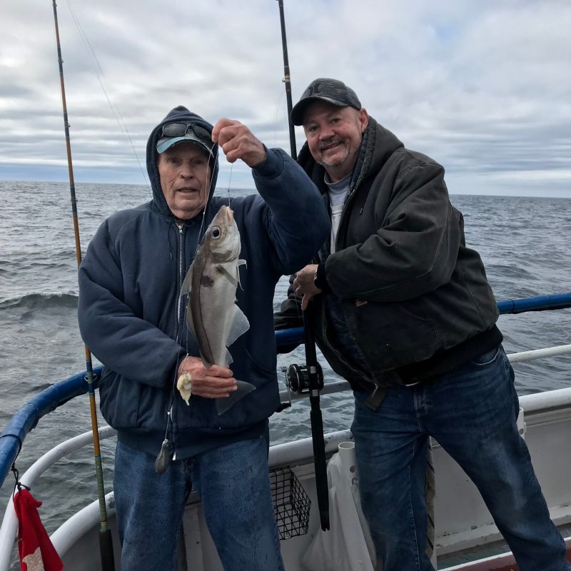 a man and a woman standing next to a body of water