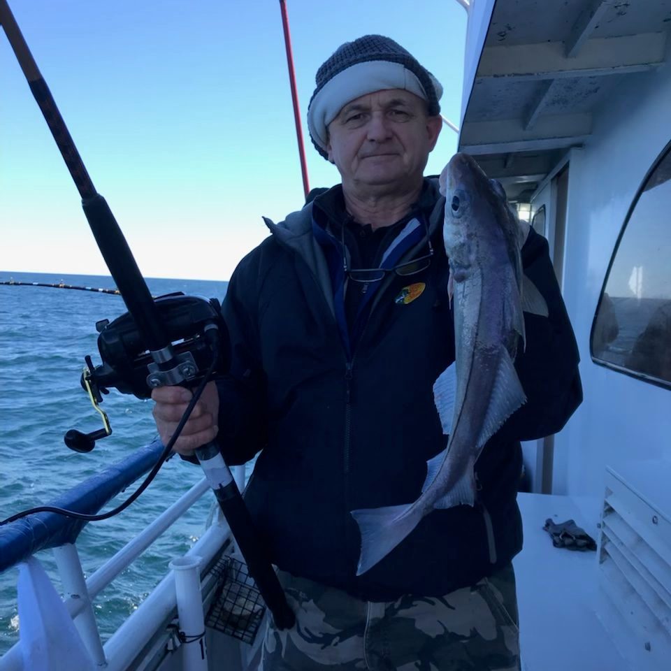 a man holding a fish on a boat
