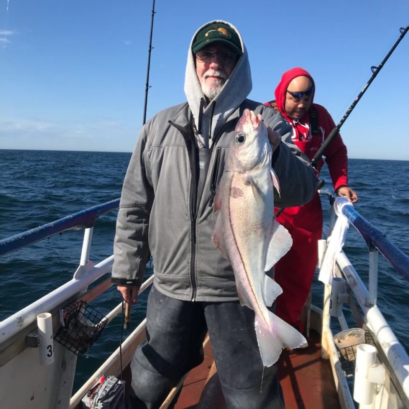 a man holding a fish on a boat
