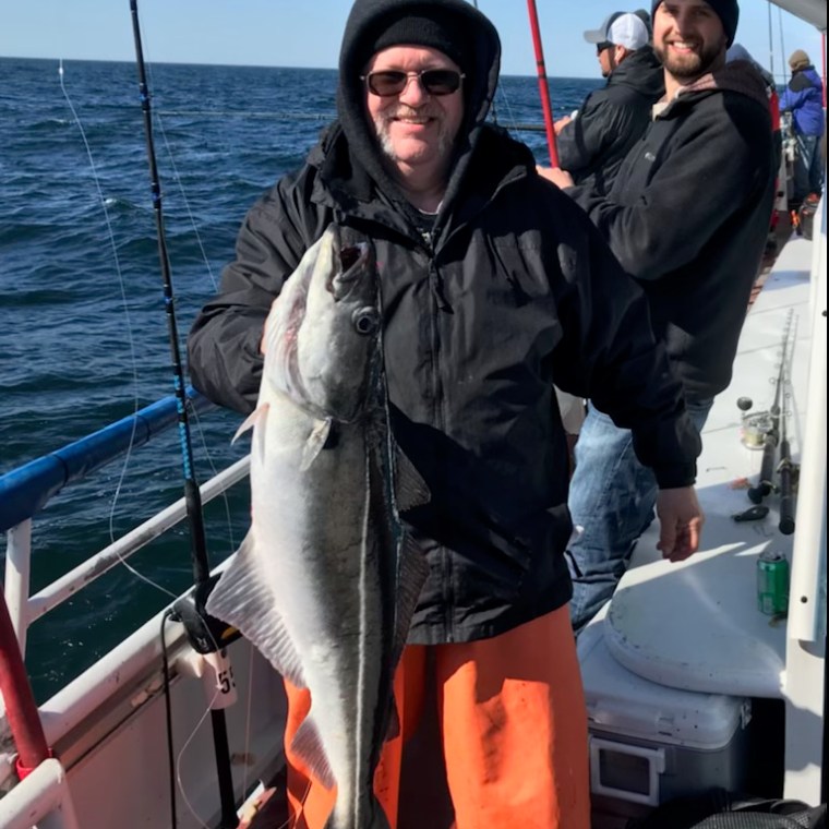 a man holding a fish on a boat