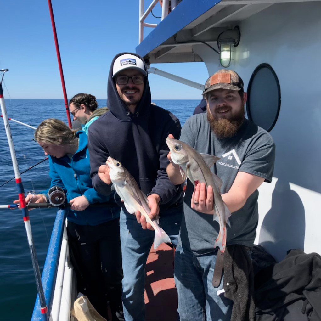 a person holding a fish on a boat posing for the camera