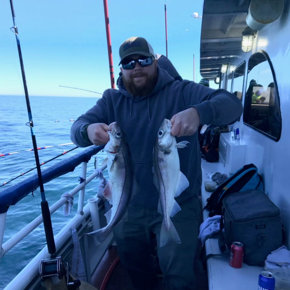 a man holding a fish on a boat