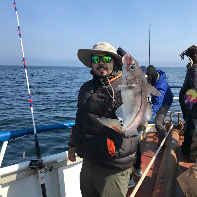 a person holding a fish on a boat