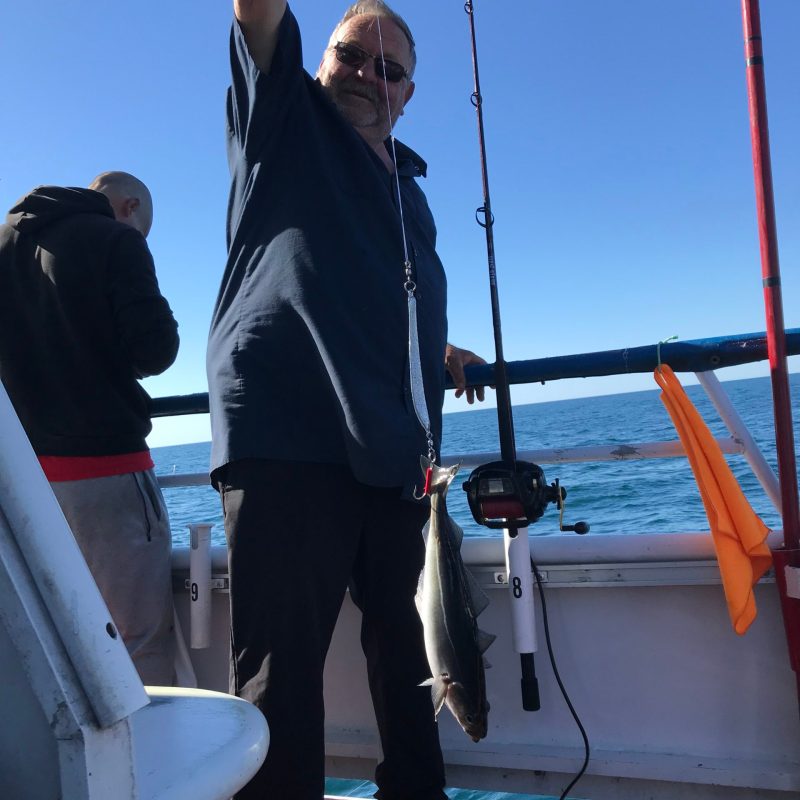 a couple of people standing next to a body of water
