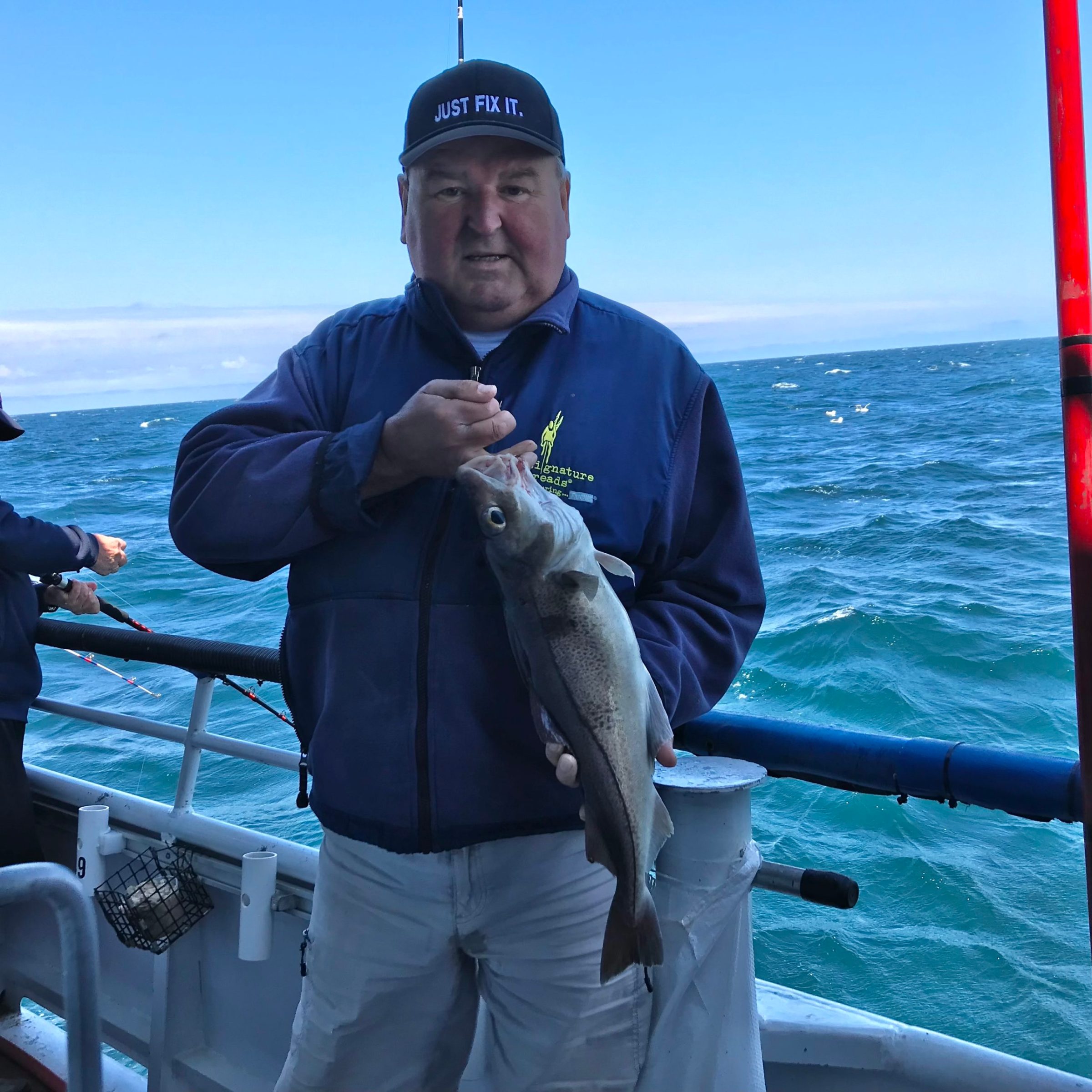 a person holding a fish on a boat in a body of water