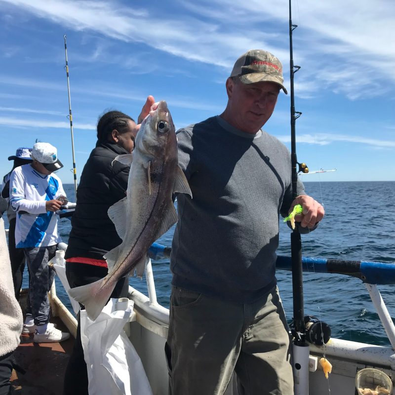 a person holding a fish on a boat