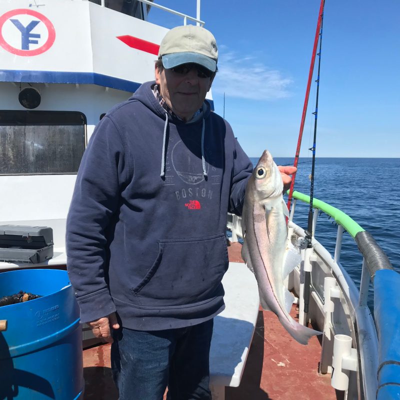 a man holding a fish on a boat