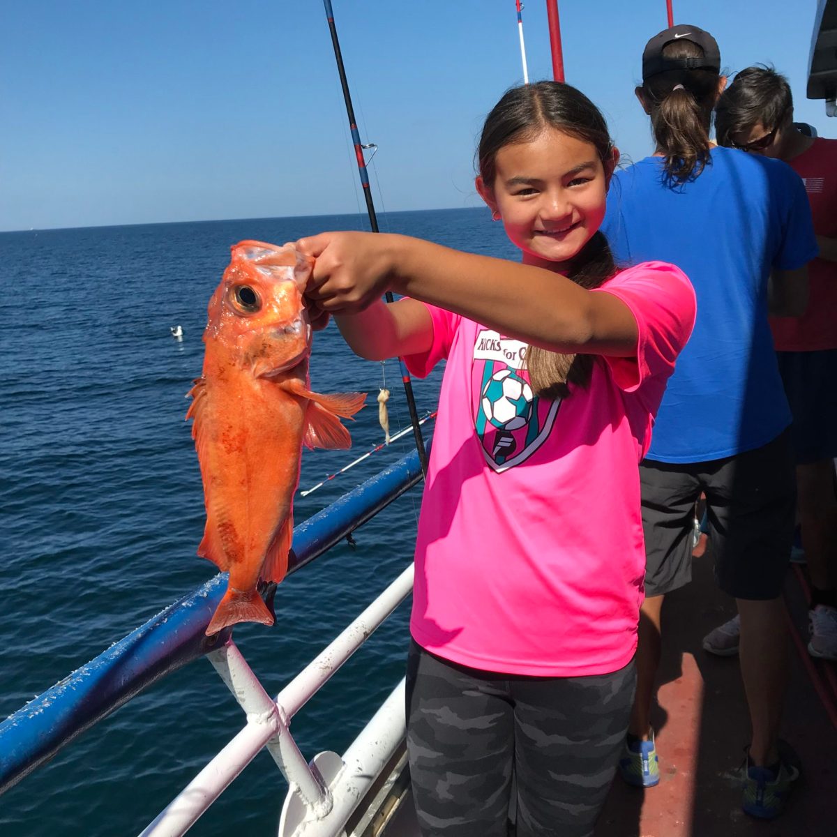 a man holding a fish on a boat
