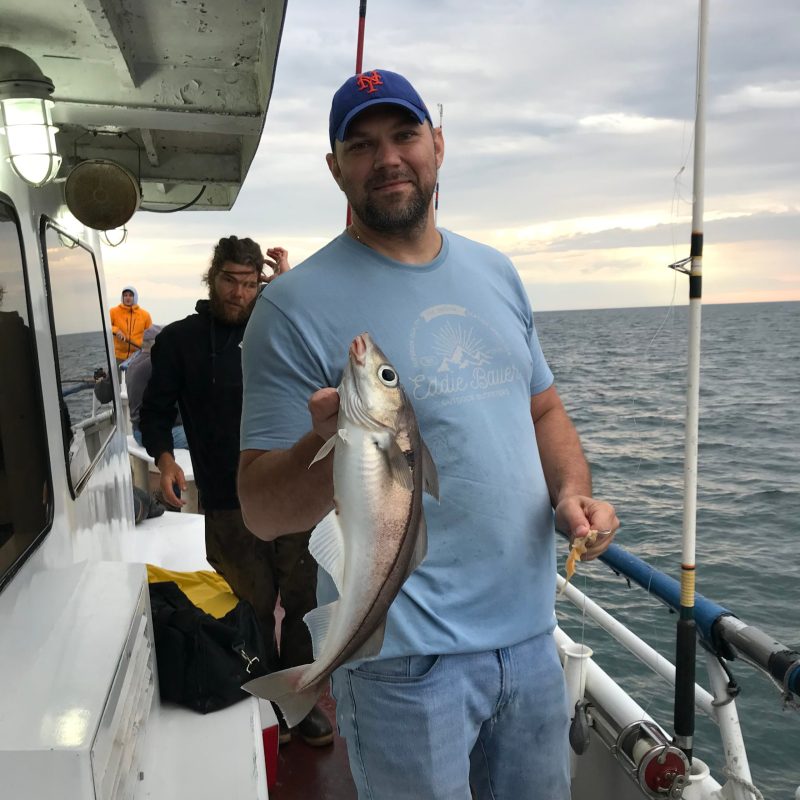 a man holding a fish on a boat