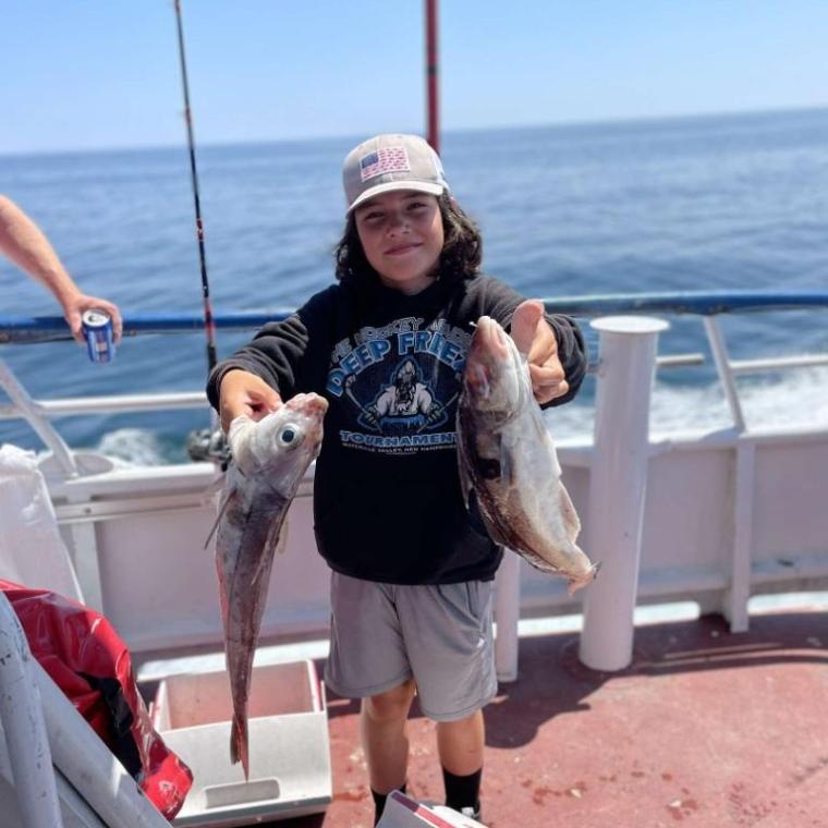 a person holding a fish on a boat in the water