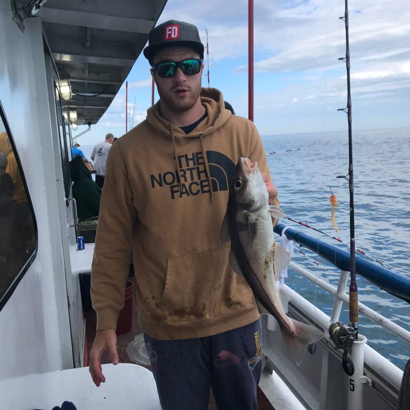 a man holding a fish on a boat