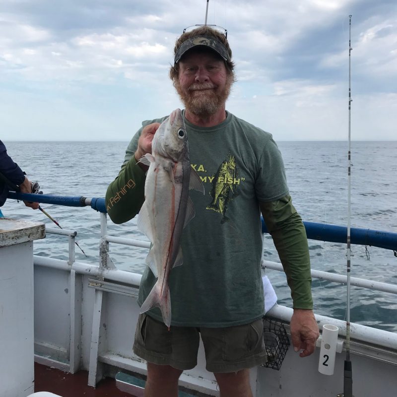 a man standing next to a body of water