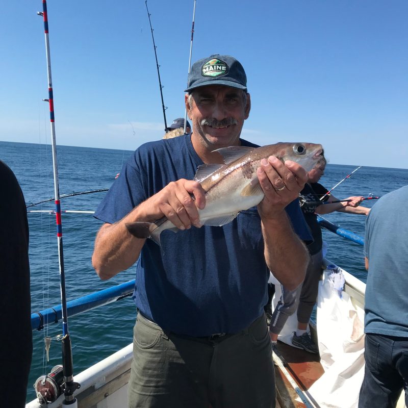 a man holding a fish in the water