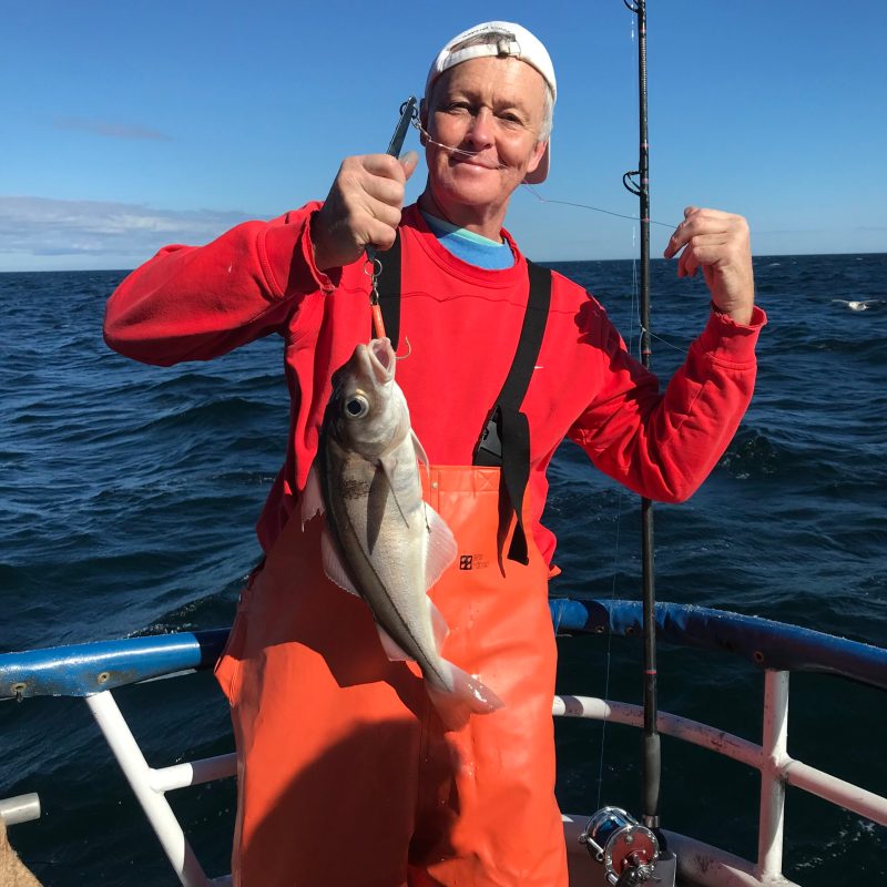 a man holding a fish in the water