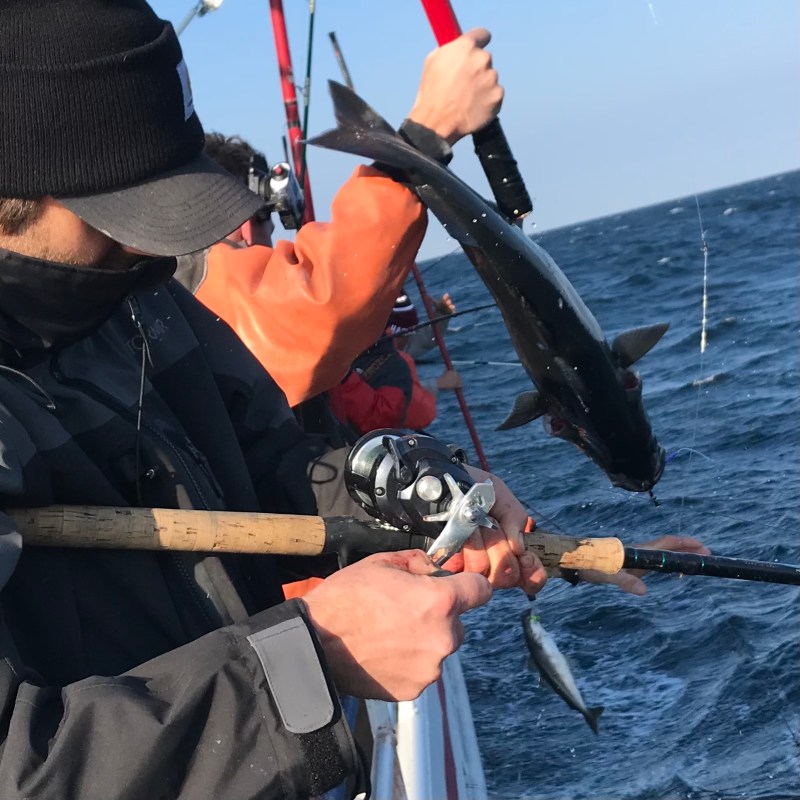 a man holding a bat on top of a boat
