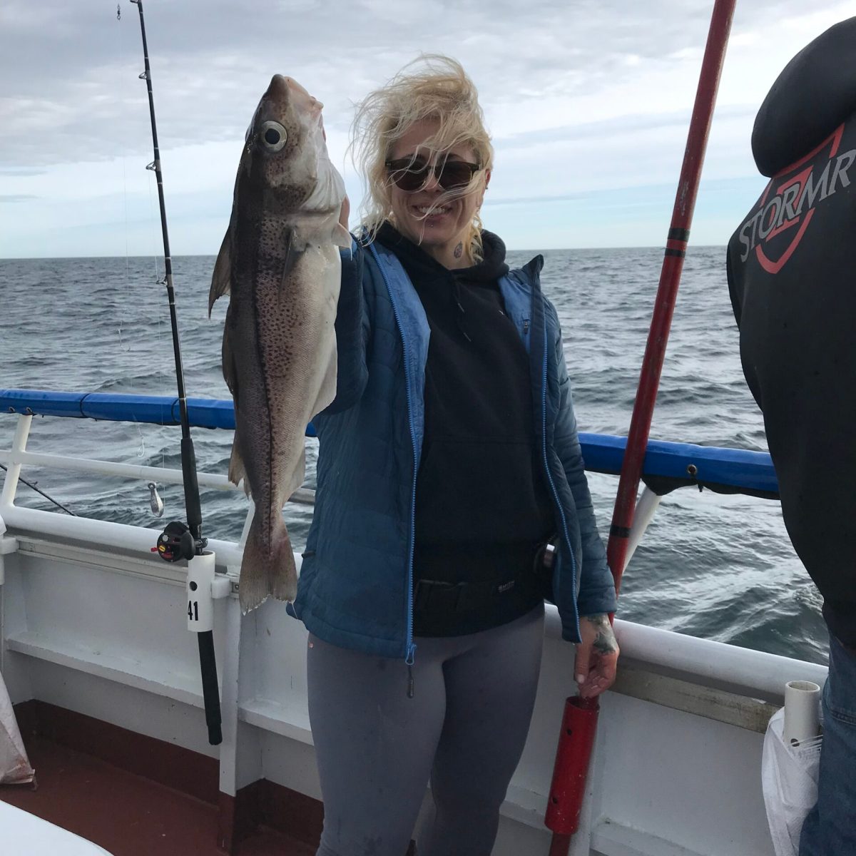 a person holding a fish on a boat in a body of water