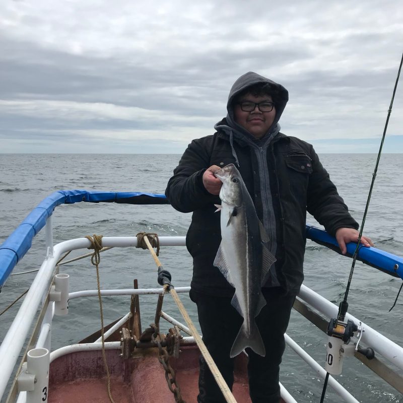 a person standing next to a boat