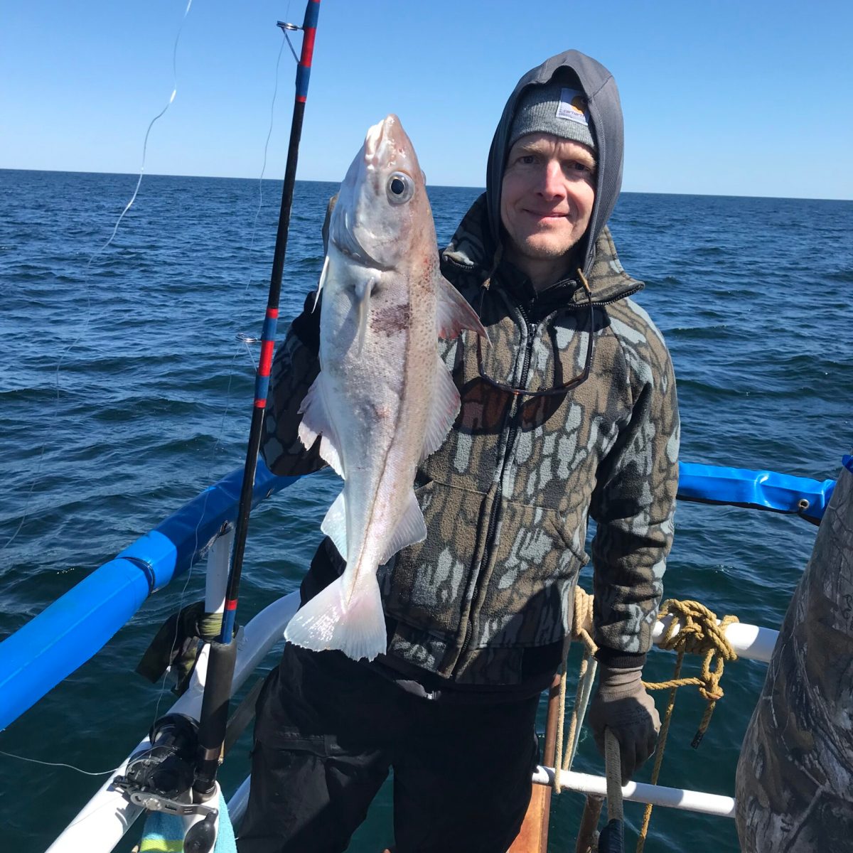a person holding a fish on a boat in a body of water