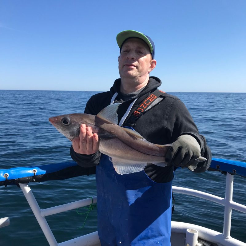 a man holding a fish in the water