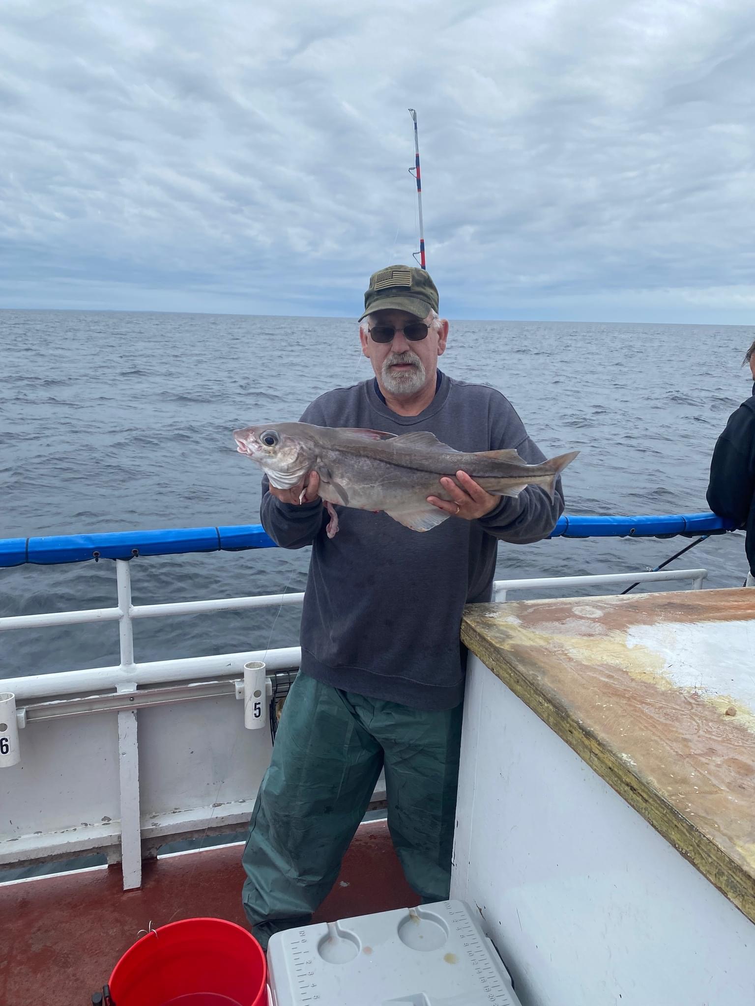 a man holding a fish on a boat in a body of water