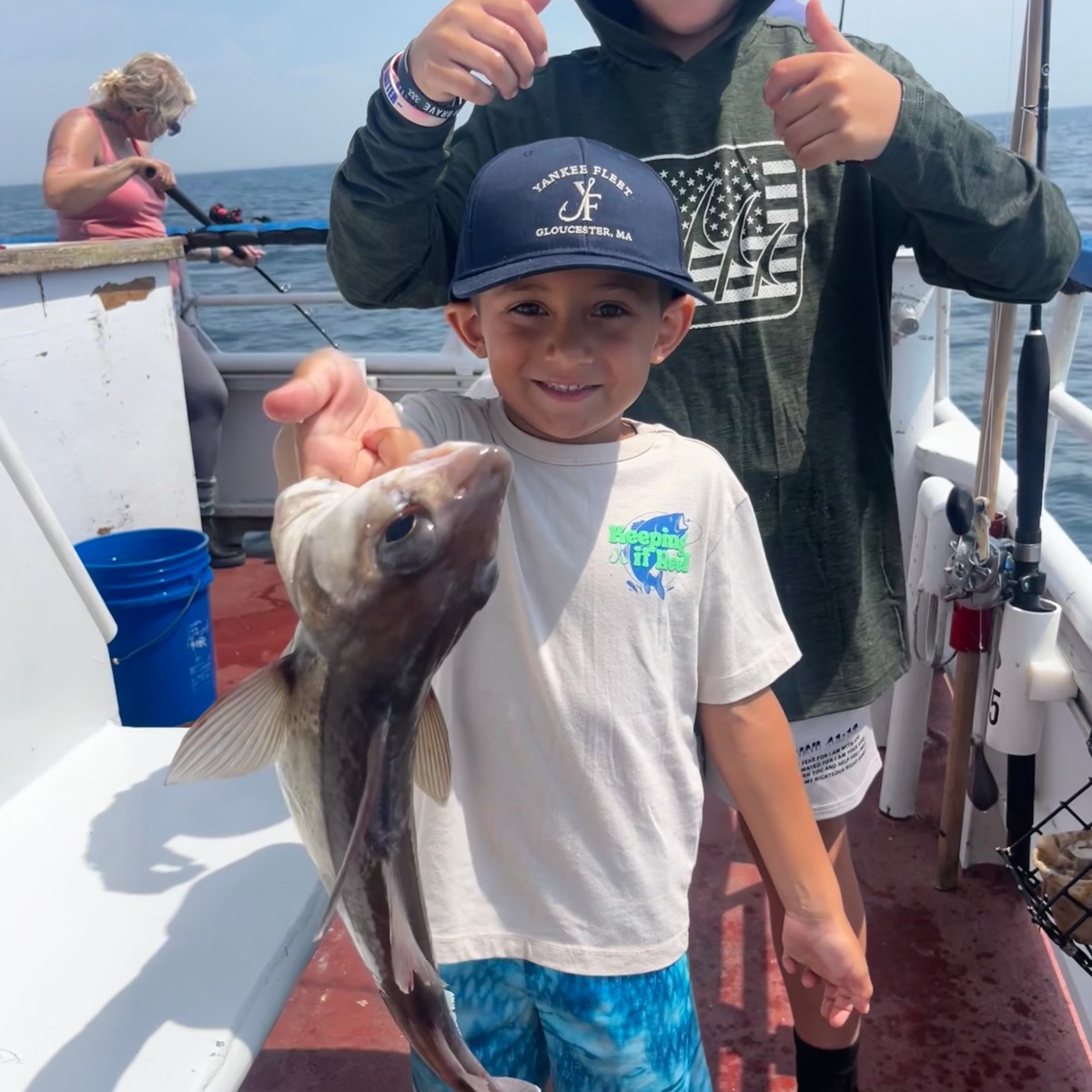a little boy holding a fish