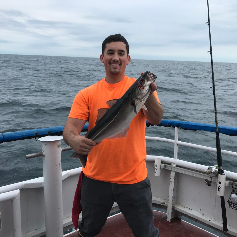 a man standing next to a body of water