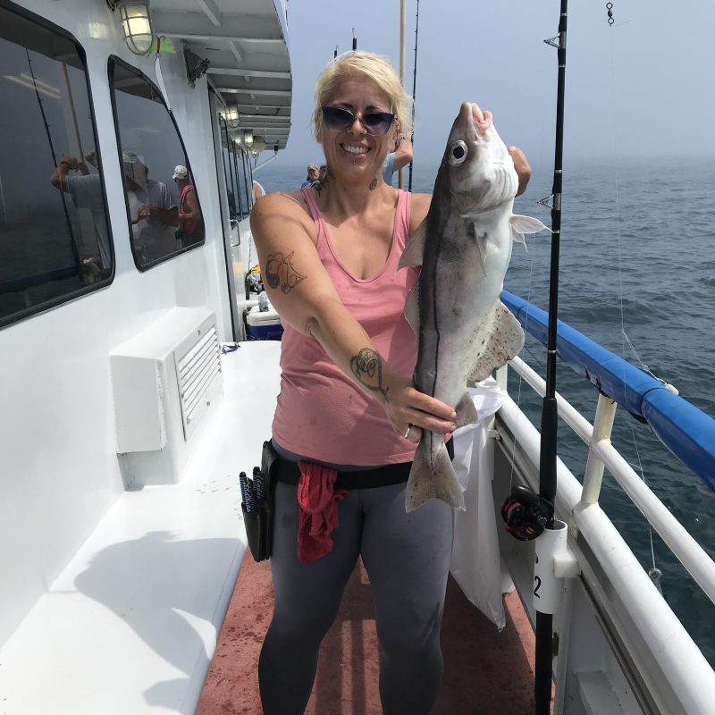 a woman holding a fish on a boat