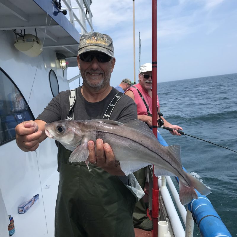a man holding a fish on a boat