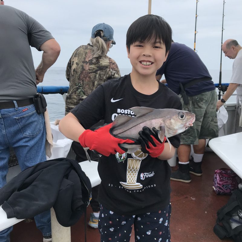 a group of people standing next to a stuffed animal