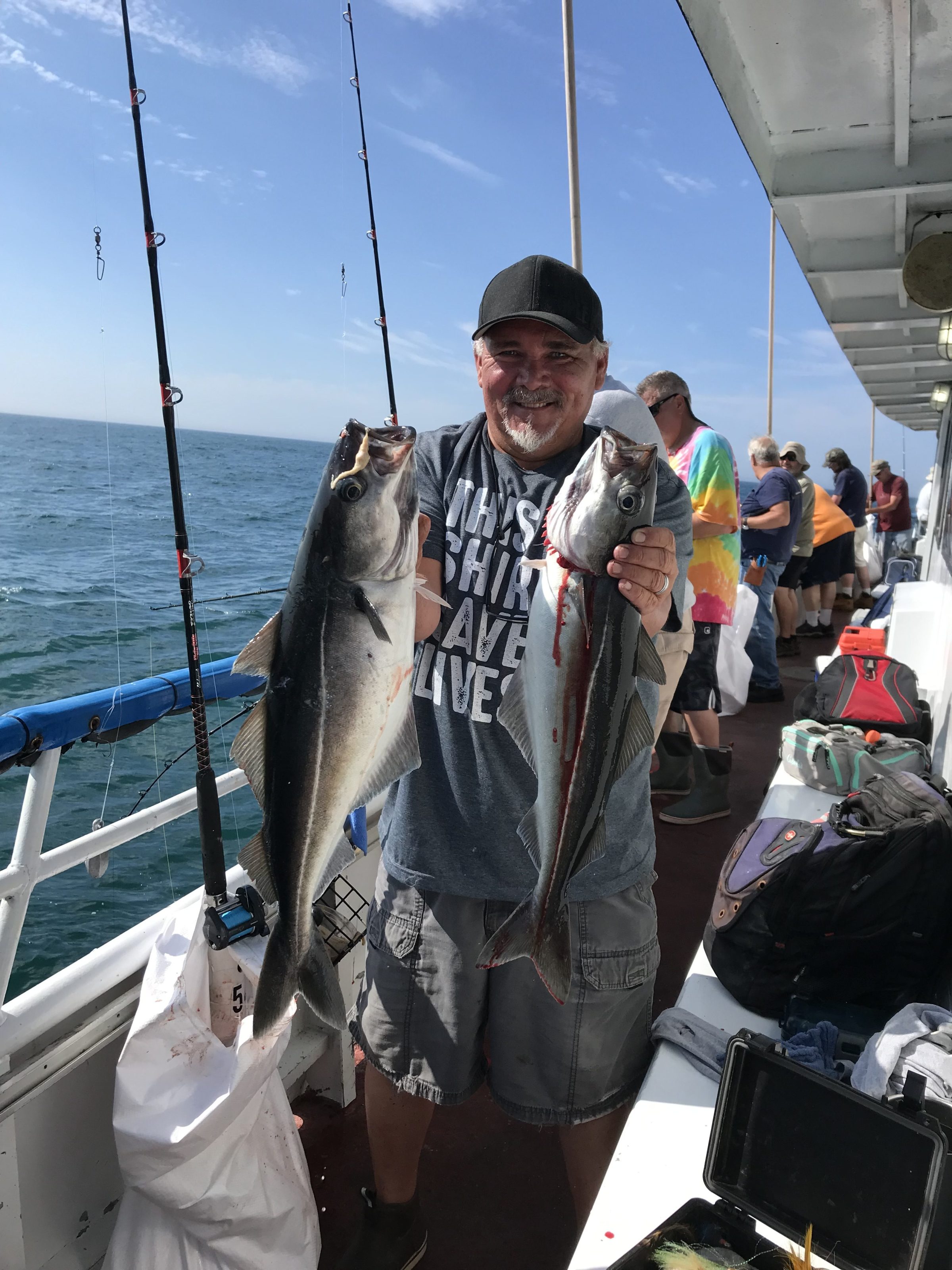 a man holding a fish on a boat